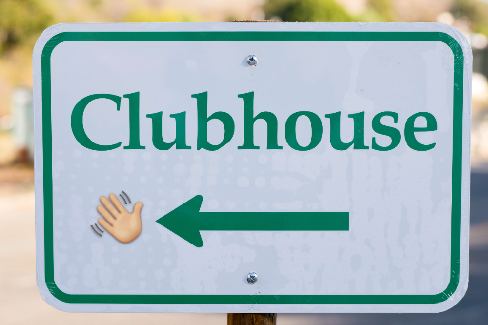 Skilt med ordet Clubhouse og pil til venstre og ei vinkande hand